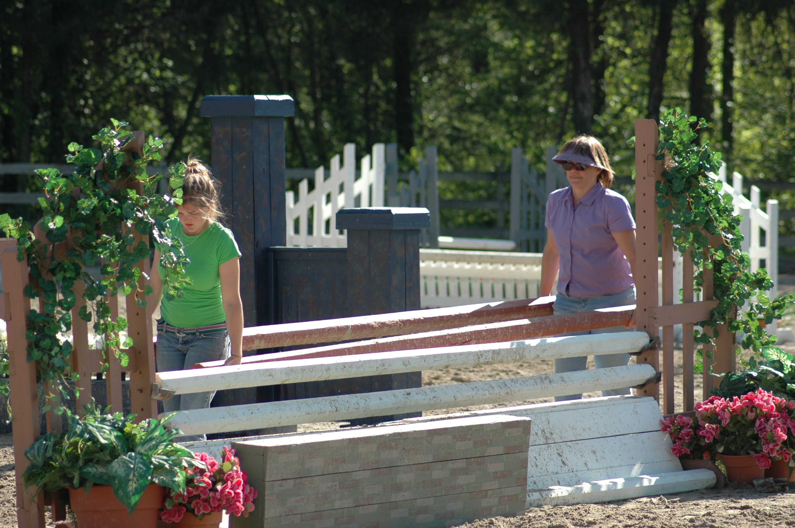 The volunteer ring crew adjusts the jumps.